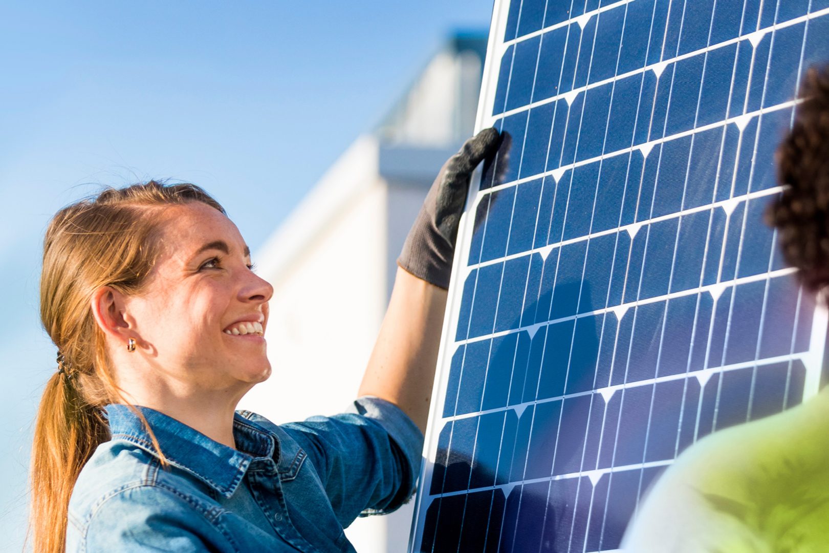 Eine Frau und ein Mann installieren ein Solar-Panel